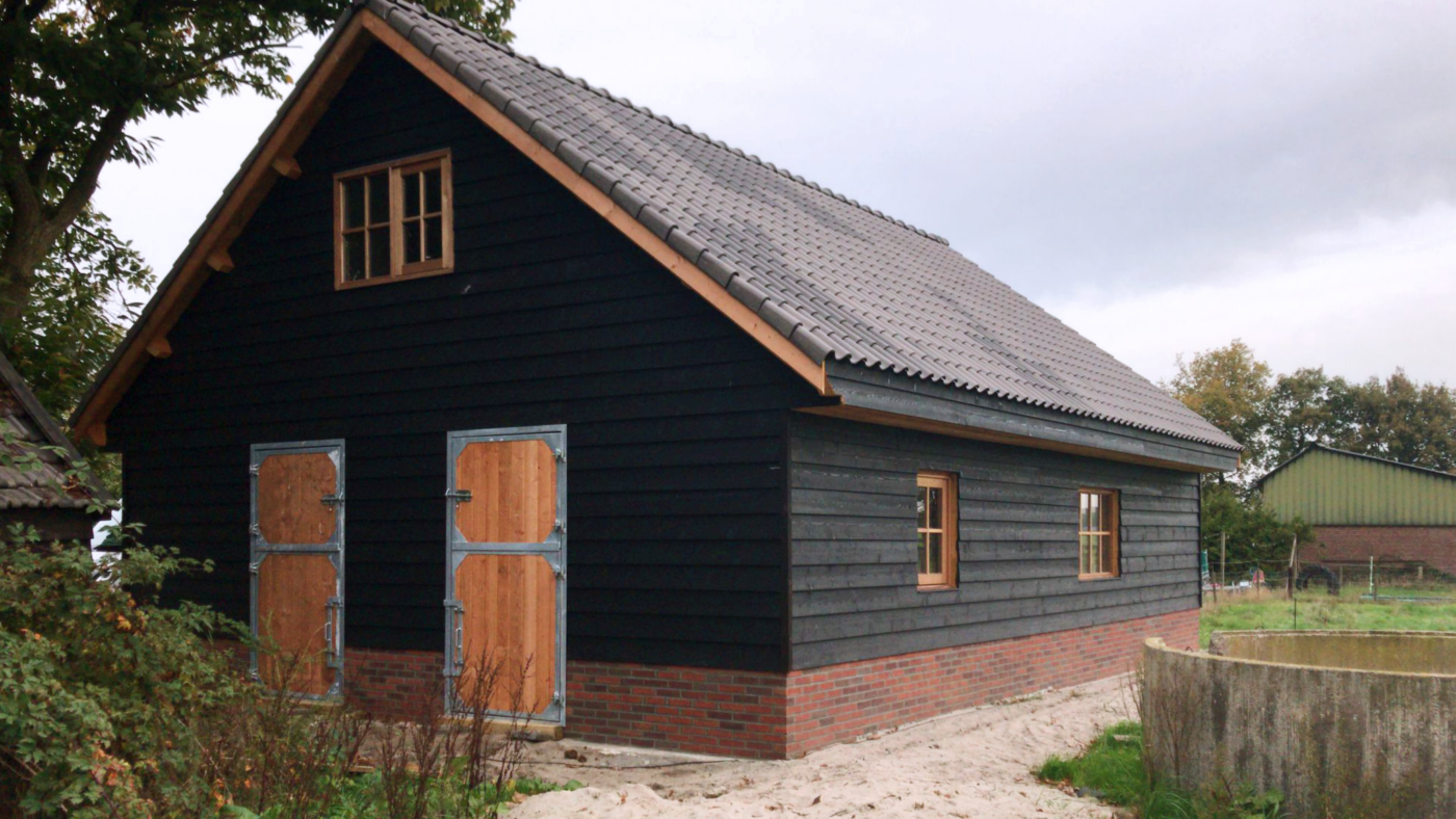 Prefab schuur met een zwart houtmotief.