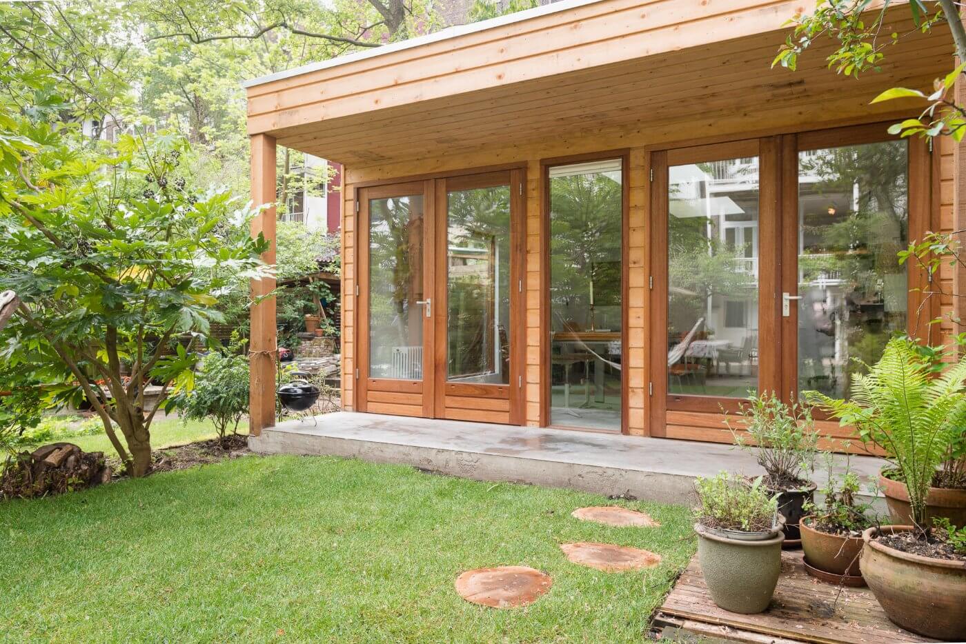 Prefab tuinhuis als gastenverblijf met luifel.