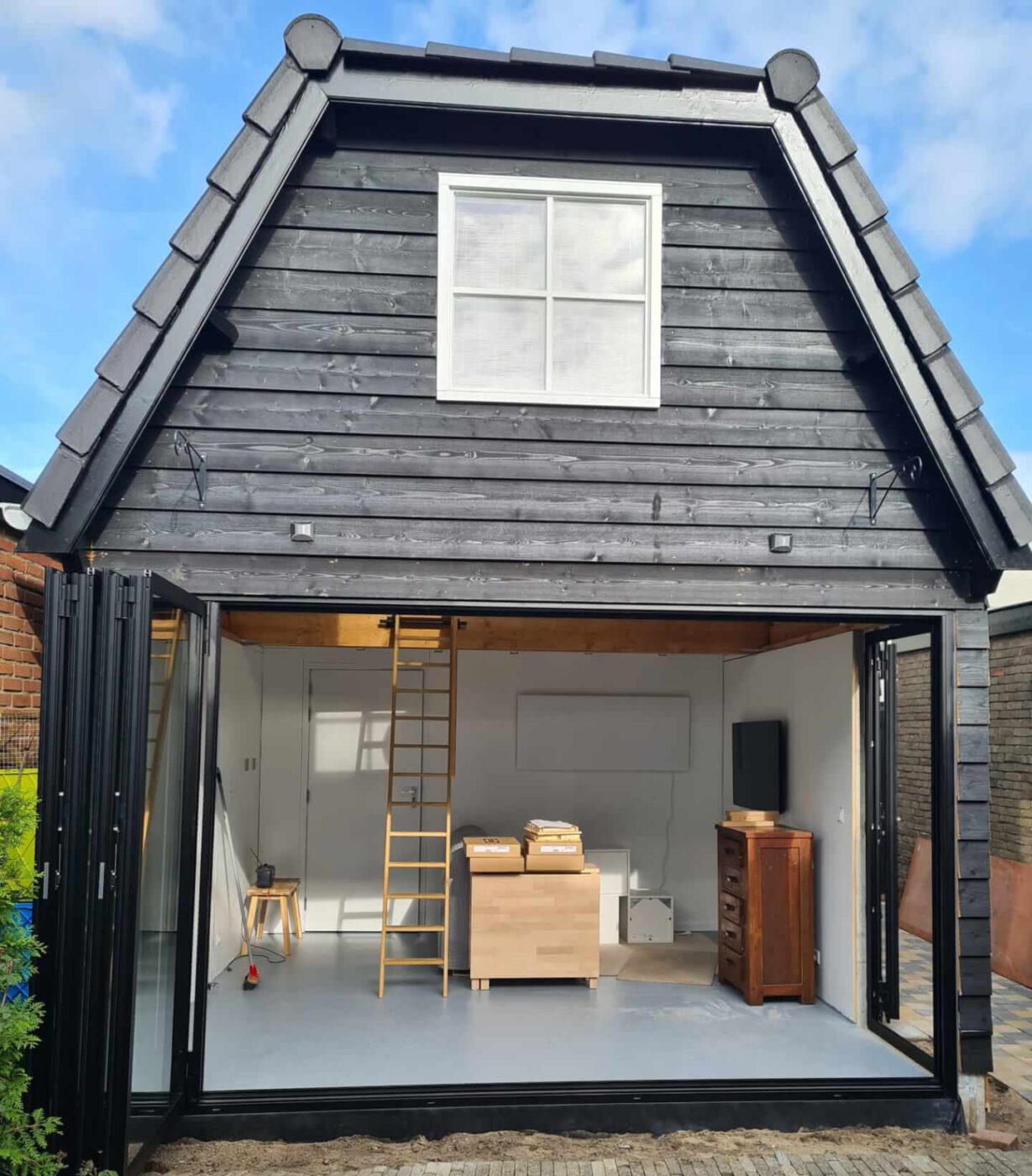 Prefab tuinkantoor met een zwart houten gevel.