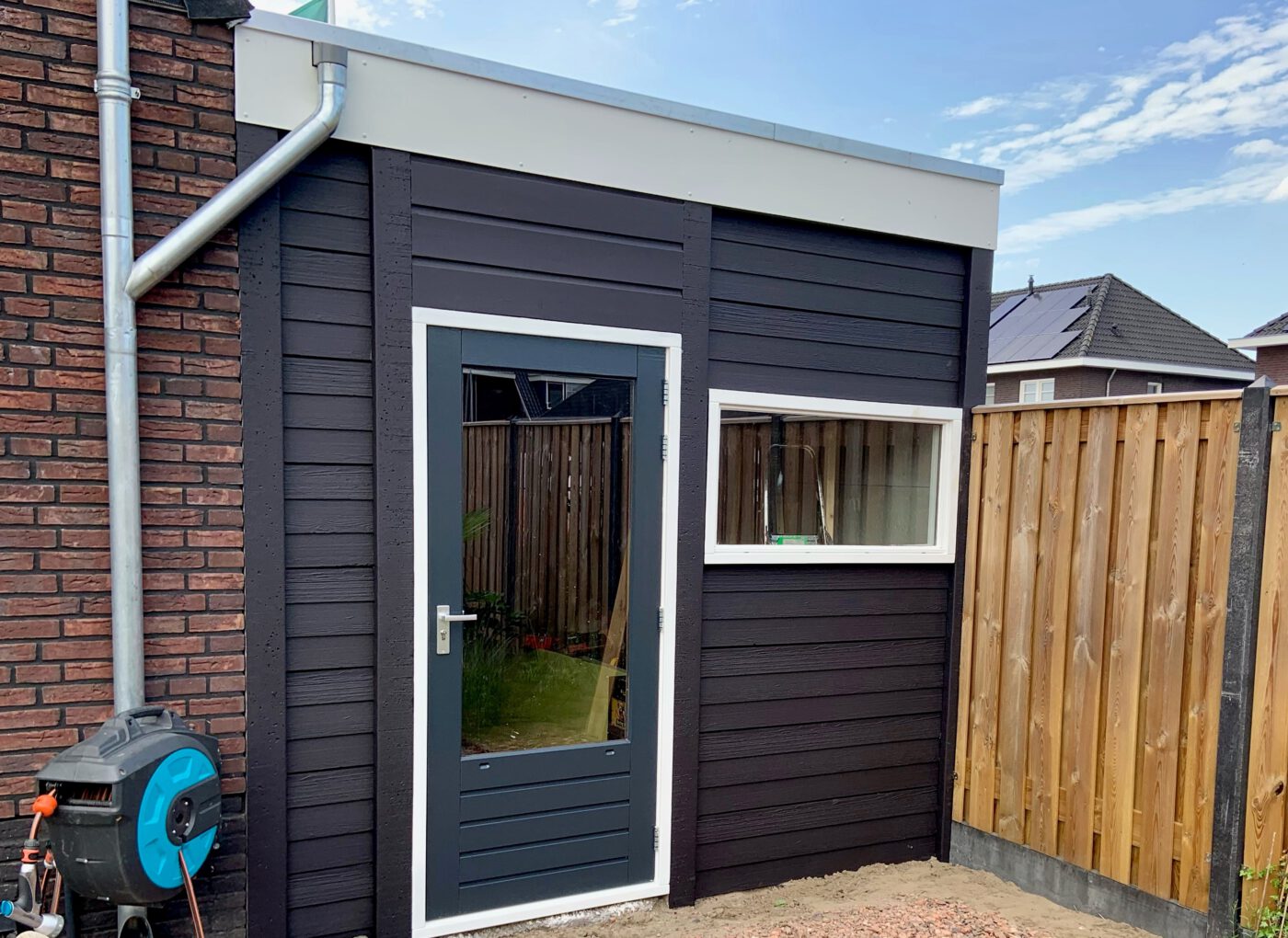 Aanbouw grage met een plat dak en een enkelwandig houtmotief.